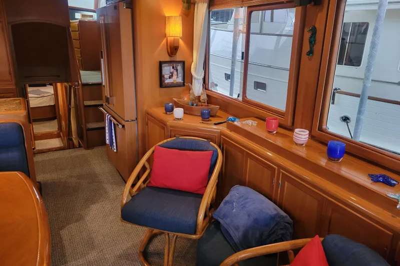 Miss Daisy Yacht Photos Pics Interior of a 2005 Fleming Pilothouse yacht with cozy seating and wooden cabinetry.