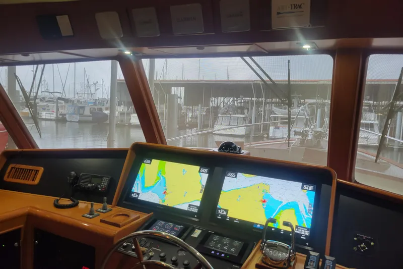Miss Daisy Yacht Photos Pics Pilothouse interior of 2005 Fleming yacht with navigation screens and marina view.