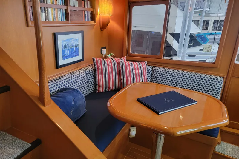 Miss Daisy Yacht Photos Pics Cozy 2005 Fleming Pilothouse interior with cushioned seating, table, and nautical decor.