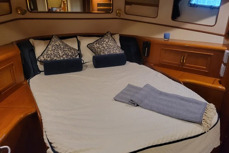 Miss Daisy Yacht Photos Pics Luxurious cabin interior of a 2005 Fleming Pilothouse yacht with cozy bedding and elegant wood finish.