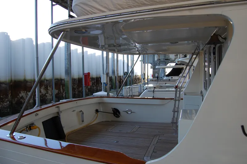 Miss Daisy Yacht Photos Pics 2005 Fleming yacht deck with wooden flooring and metal railings in a marina.