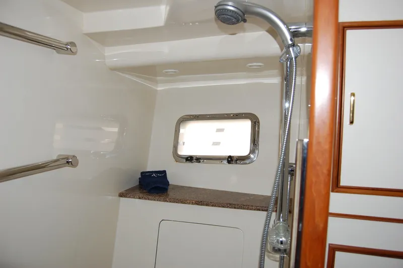 Miss Daisy Yacht Photos Pics Luxurious 2005 Fleming yacht bathroom with shower, porthole, and wooden cabinetry.