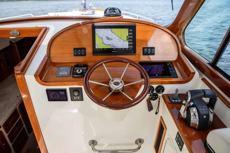 Sublime Yacht Photos Pics 2022 Hinckley 35 boat helm with wooden steering wheel and navigation display.