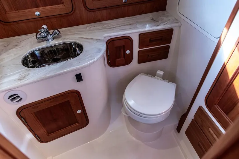 Sublime Yacht Photos Pics Luxurious 2022 Hinckley 35 yacht bathroom with elegant wood cabinetry and modern fixtures.
