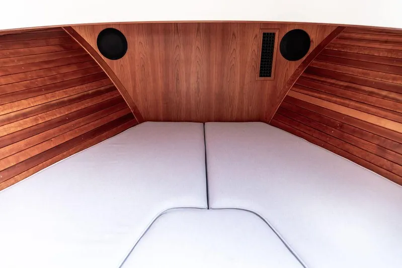 Sublime Yacht Photos Pics Interior cabin of 2022 Hinckley 35 boat with wooden paneling and cushioned seating.