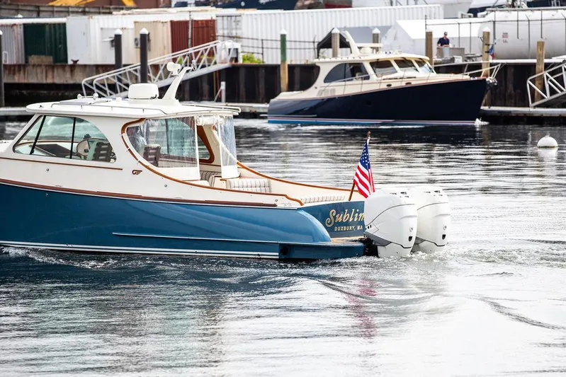 Sublime Yacht Photos Pics Hinckley 35 boat, 2022 model, cruising in a marina with American flag.