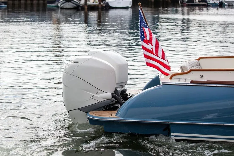 Sublime Yacht Photos Pics Hinckley 35 boat, 2022 model, with American flag and outboard motor on water.