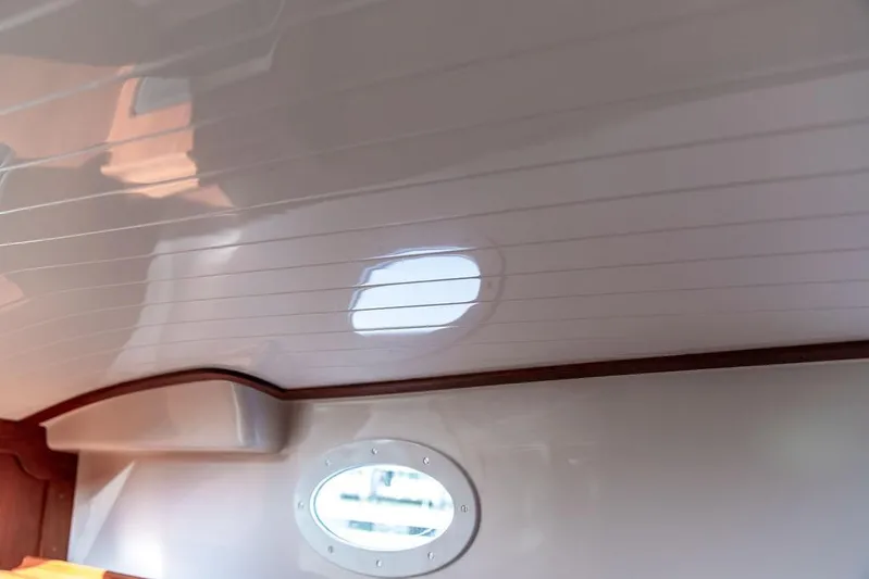 Sublime Yacht Photos Pics Interior view of 2022 Hinckley 35 boat, featuring sleek, polished ceiling and oval window.