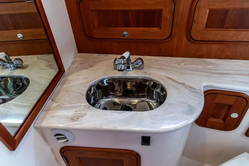 Sublime Yacht Photos Pics Elegant bathroom sink in 2022 Hinckley 35 yacht, featuring marble countertop and wooden cabinetry.