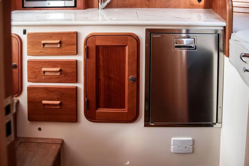 Sublime Yacht Photos Pics Hinckley 35 yacht interior, featuring wooden cabinetry and stainless steel appliances, 2022 model.