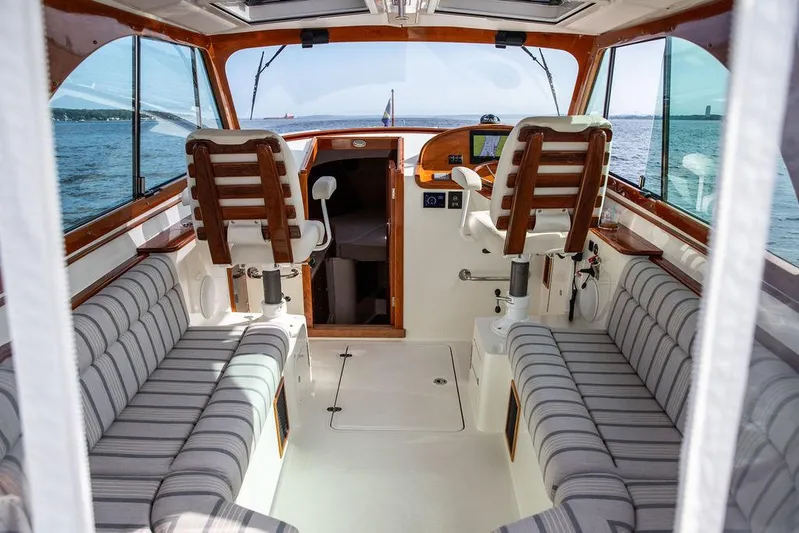 Sublime Yacht Photos Pics Interior of 2022 Hinckley 35 boat with striped seating and wooden accents.