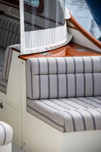 Sublime Yacht Photos Pics 2022 Hinckley 35 boat interior with striped seating and wooden accents.
