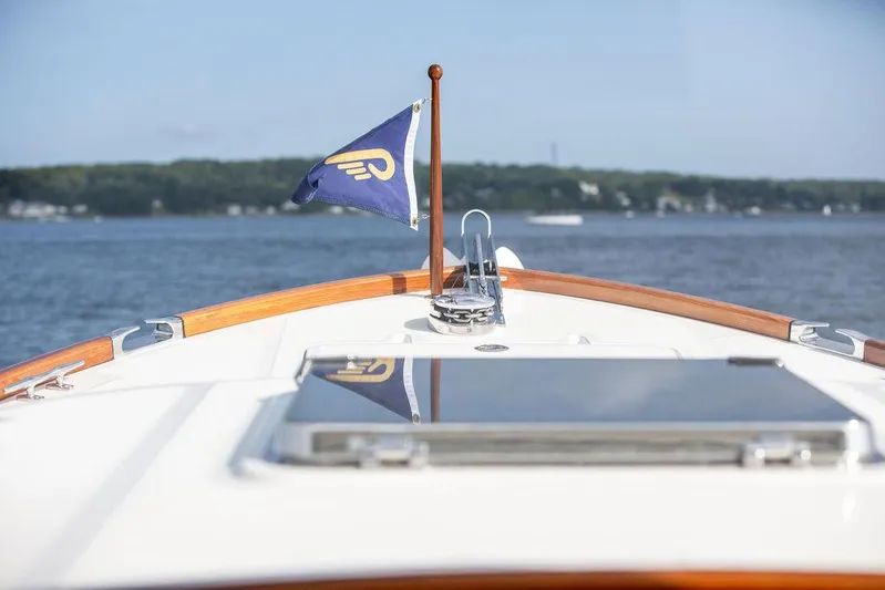 Sublime Yacht Photos Pics Hinckley 35 yacht bow with flag, cruising on a serene lake, 2022 model.