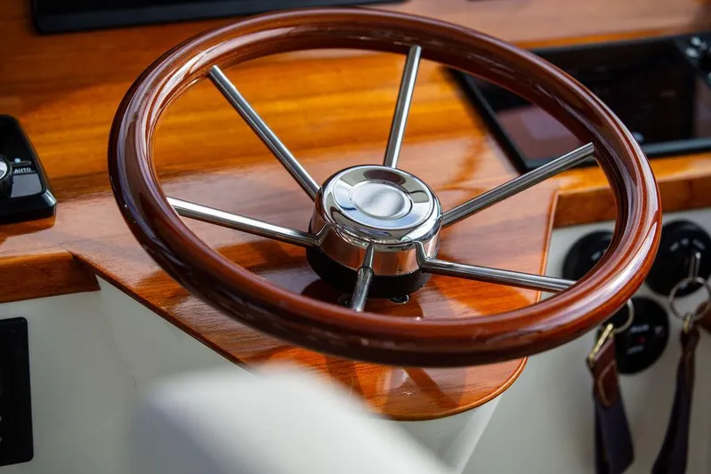 Sublime Yacht Photos Pics Steering wheel of a 2022 Hinckley 35 boat, featuring polished wood and metal accents.