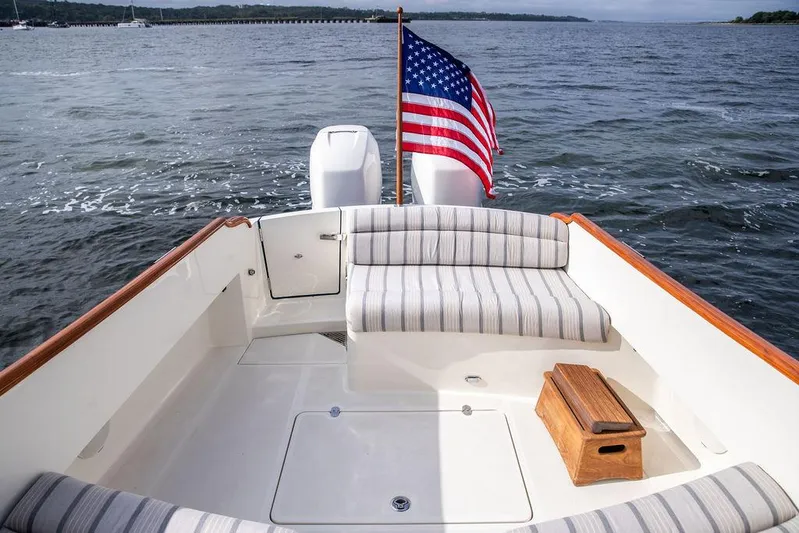 Sublime Yacht Photos Pics Hinckley 35 boat deck with striped seating and American flag, 2022 model.