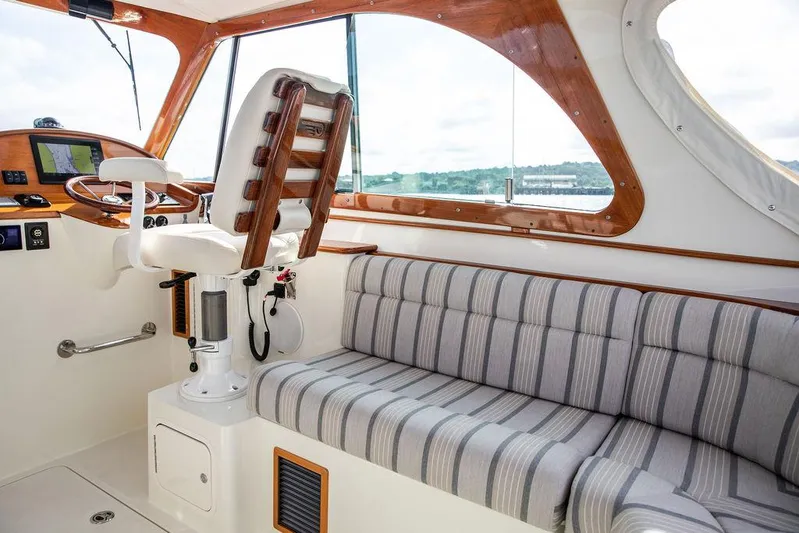Sublime Yacht Photos Pics Interior of 2022 Hinckley 35 boat with striped seating and wooden accents.