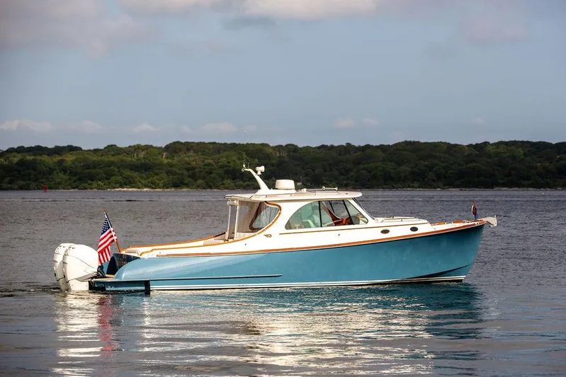 Sublime Yacht Photos Pics 2022 Hinckley 35 boat on calm water with American flag, scenic background.
