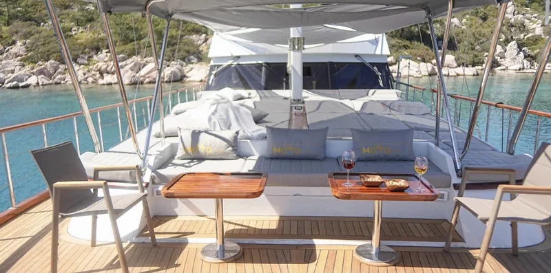  Yacht Photos Pics Luxurious 2023 Gulet yacht deck with seating, tables, and scenic ocean view.