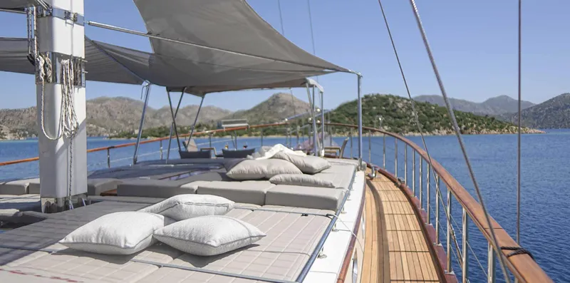  Yacht Photos Pics Luxurious 2023 Gulet yacht deck with cushions, scenic sea and mountain views.
