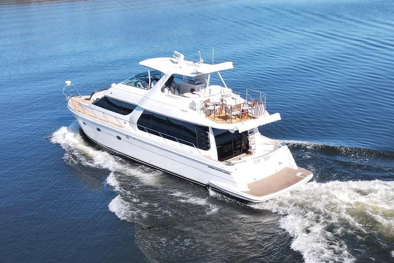  Yacht Photos Pics 2002 Carver 570 Voyager Pilothouse yacht cruising on calm blue waters.