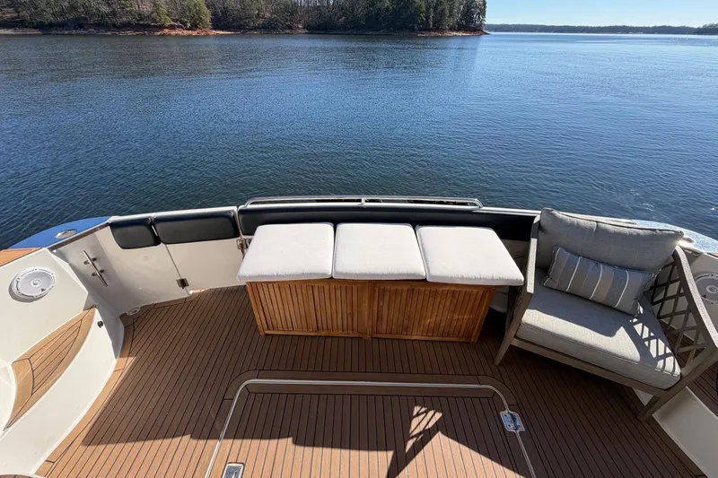  Yacht Photos Pics 2002 Carver 570 Voyager Pilothouse deck with seating, overlooking serene water and distant trees.