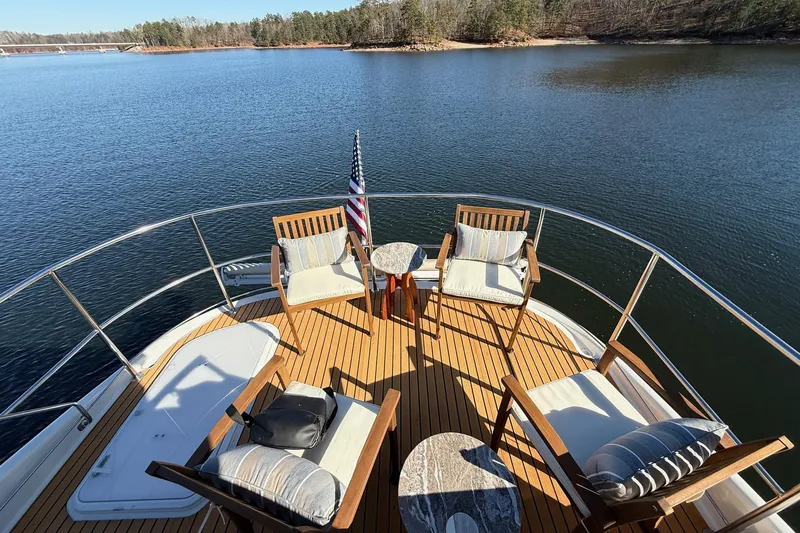  Yacht Photos Pics Deck view of 2002 Carver 570 Voyager Pilothouse with chairs and table on calm water.