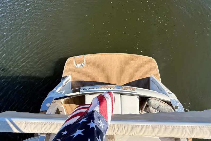  Yacht Photos Pics 2002 Carver 570 Voyager Pilothouse yacht with American flag, viewed from above.