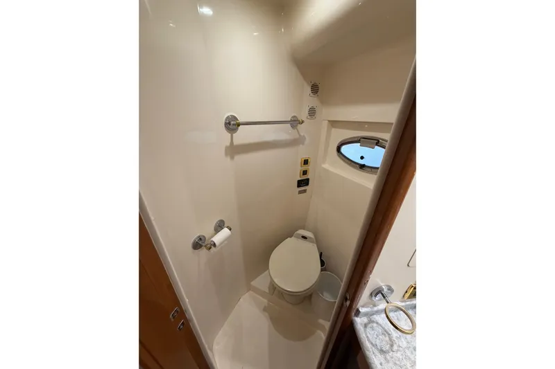  Yacht Photos Pics Bathroom interior of 2002 Carver 570 Voyager Pilothouse yacht with toilet and porthole.