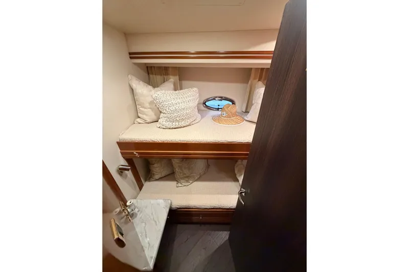 Yacht Photos Pics Cozy cabin interior of 2002 Carver 570 Voyager Pilothouse with bunk beds and porthole.