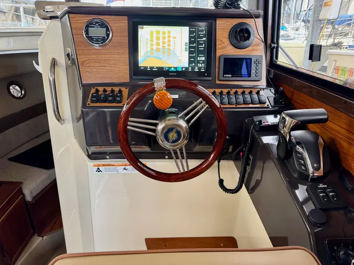  Yacht Photos Pics 2023 Ranger Tugs R-25 helm with modern navigation system and wooden steering wheel.