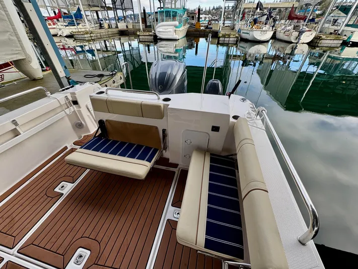  Yacht Photos Pics 2023 Ranger Tugs R-25 boat interior with cushioned seating, docked at marina.