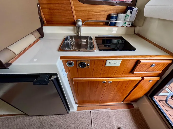  Yacht Photos Pics 2023 Ranger Tugs R-25 galley with sink, stove, and compact fridge.