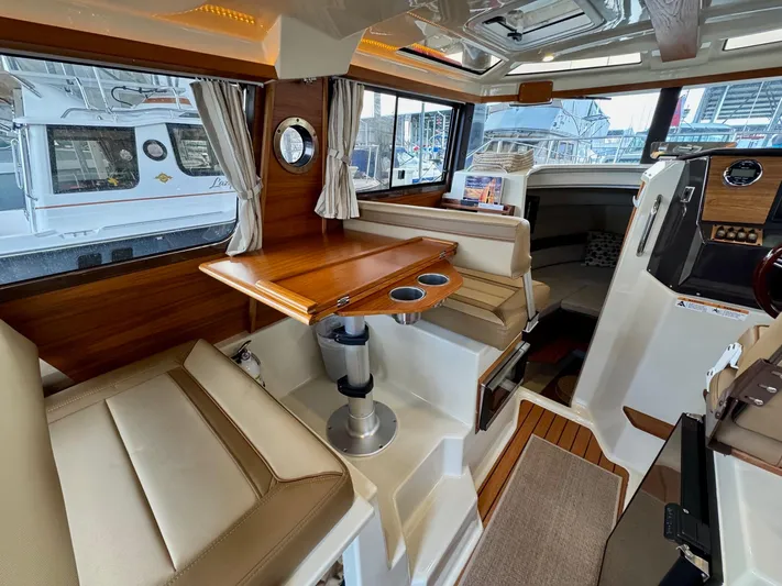  Yacht Photos Pics Interior of 2023 Ranger Tugs R-25 boat with seating and wooden table.
