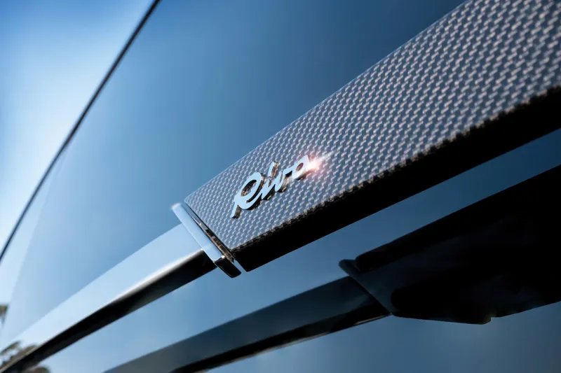  Yacht Photos Pics Close-up of 2025 Riva Folgore logo on sleek carbon fiber surface.