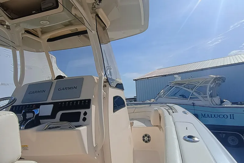 271-508 Brokerage Joe Yacht Photos Pics 2023 Grady-White Canyon 271 boat with Garmin navigation, docked near another vessel.