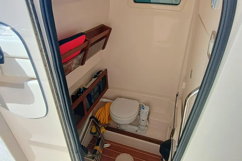 271-508 Brokerage Joe Yacht Photos Pics 2023 Grady-White Canyon 271 boat interior with compact bathroom and storage shelves.
