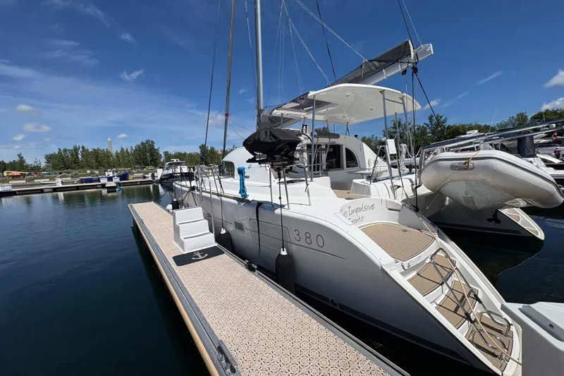 Too Impulsive Yacht Photos Pics 2014 Lagoon 380 S2 catamaran docked at marina under clear blue sky.