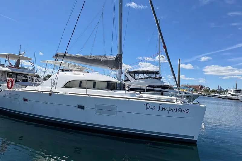 Too Impulsive Yacht Photos Pics 2014 Lagoon 380 S2 catamaran "Two Impulsive" docked in a marina under blue skies.