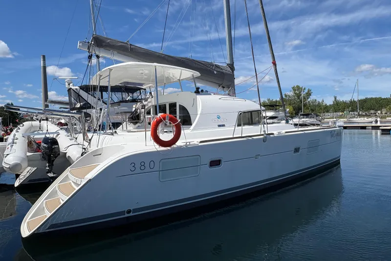 Too Impulsive Yacht Photos Pics 2014 Lagoon 380 S2 catamaran docked in marina under blue sky.
