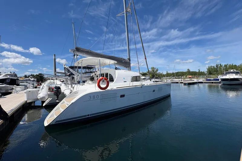 Too Impulsive Yacht Photos Pics 2014 Lagoon 380 S2 catamaran docked at marina under clear blue sky.