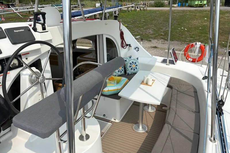 Too Impulsive Yacht Photos Pics Cockpit of 2014 Lagoon 380 S2 catamaran with seating, table, and steering wheel.