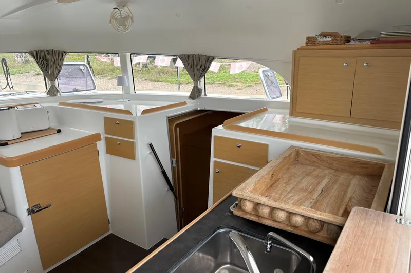 Too Impulsive Yacht Photos Pics Interior of 2014 Lagoon 380 S2 catamaran with modern kitchen and wooden cabinetry.