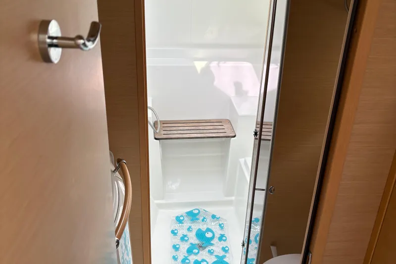 Too Impulsive Yacht Photos Pics Bathroom interior of 2014 Lagoon 380 S2 yacht with wooden accents and blue mat.