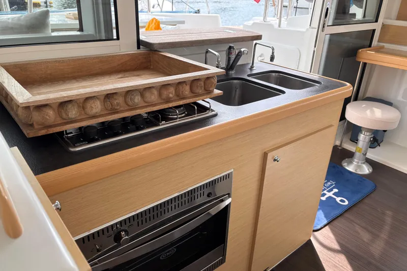 Too Impulsive Yacht Photos Pics Modern kitchen area in a 2014 Lagoon 380 S2 catamaran with stove and sink.