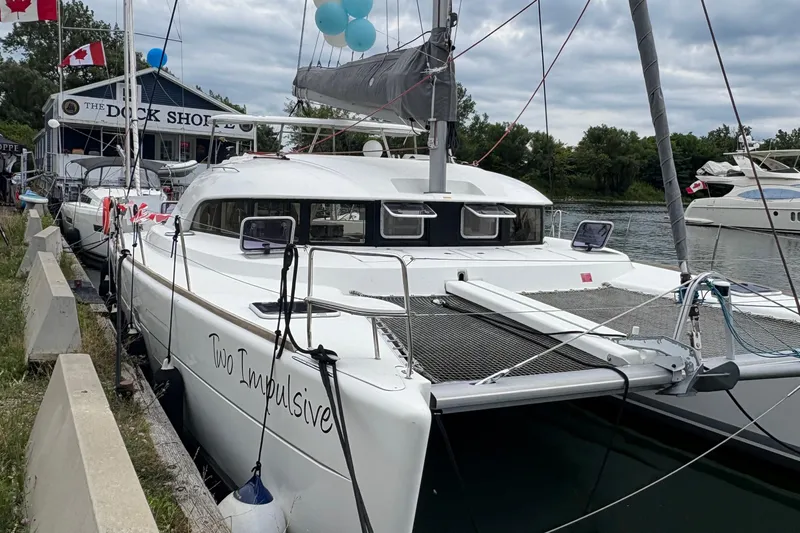 Too Impulsive Yacht Photos Pics 2014 Lagoon 380 S2 catamaran docked, featuring "Two Impulsive" name, with flags and balloons.