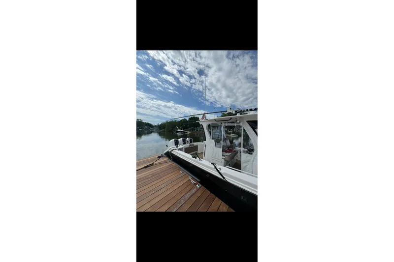  Yacht Photos Pics 2017 Edgewater 368CC boat docked on a sunny day with cloudy sky.