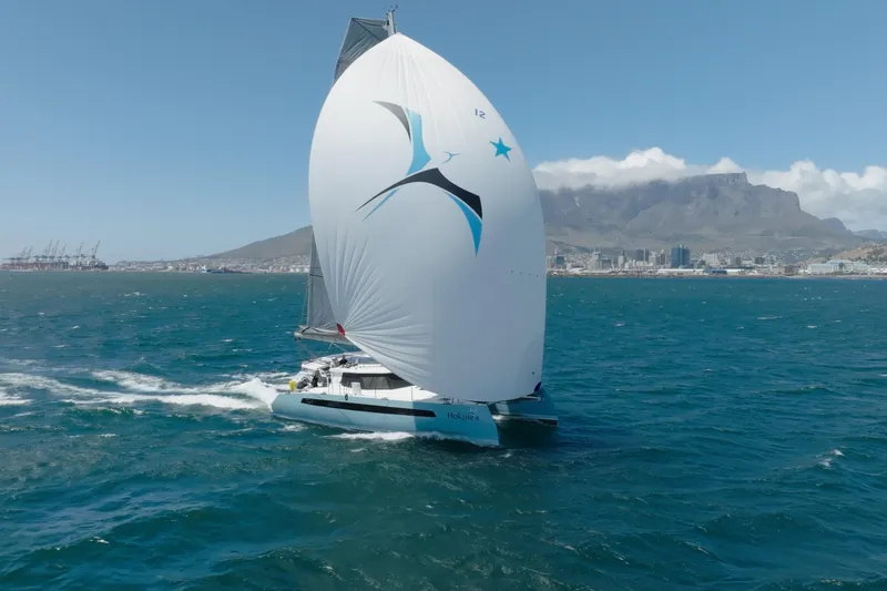 Hokule'a Yacht Photos Pics Balance 482, Hokulea slicing through the ocean with Capetown and Table mountain backdrop.