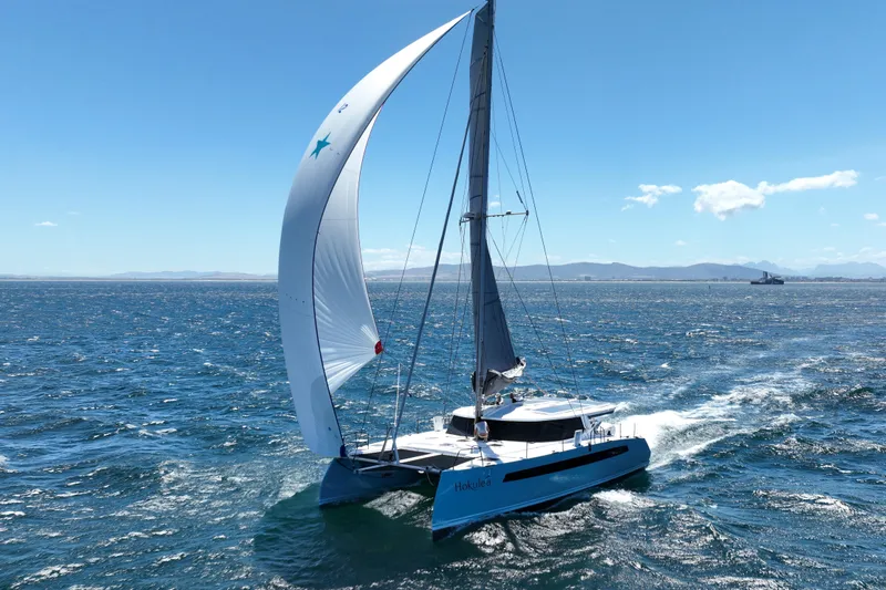 Hokule'a Yacht Photos Pics Sailing catamaran Balance 482, 2024 model, gliding on open sea under clear blue sky.