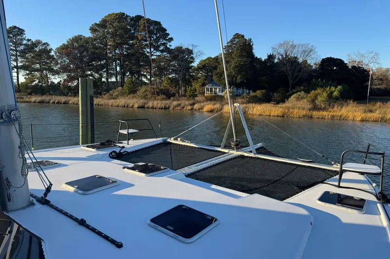 Hokule'a Yacht Photos Pics 2024 Balance 482 catamaran on serene river with lush trees in background.