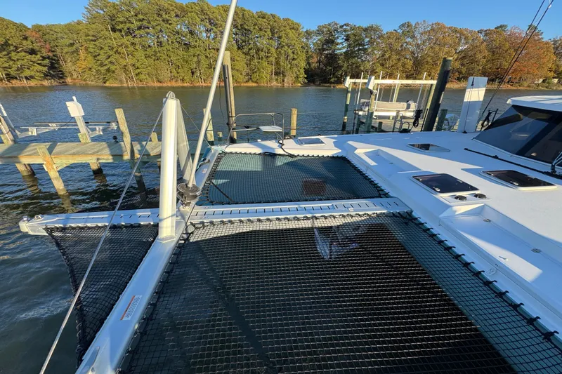 Hokule'a Yacht Photos Pics 2024 Balance 482 catamaran docked by a serene lakeside with lush trees.